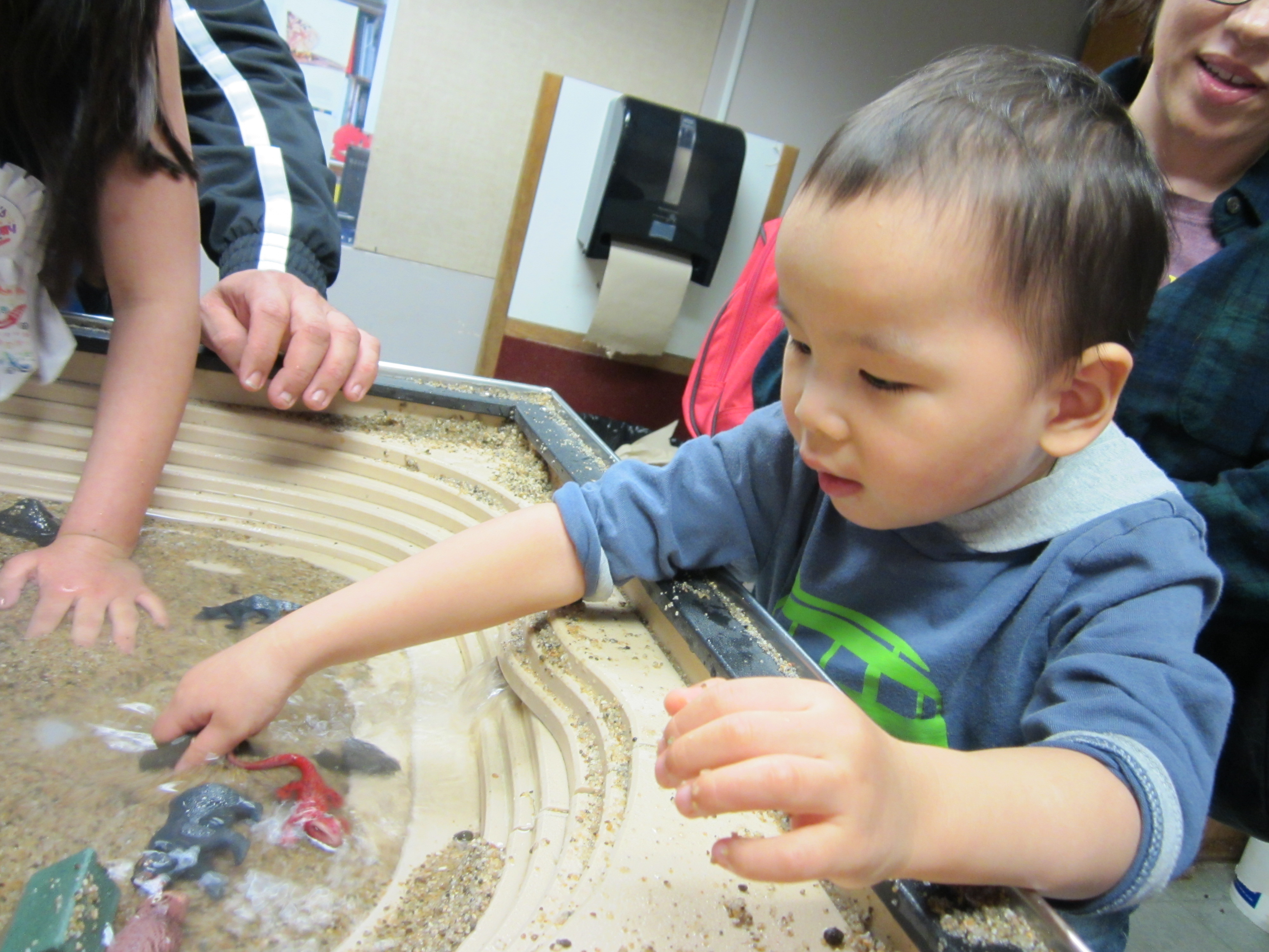 Tai loved splashing at the table where he could build a stream bed.