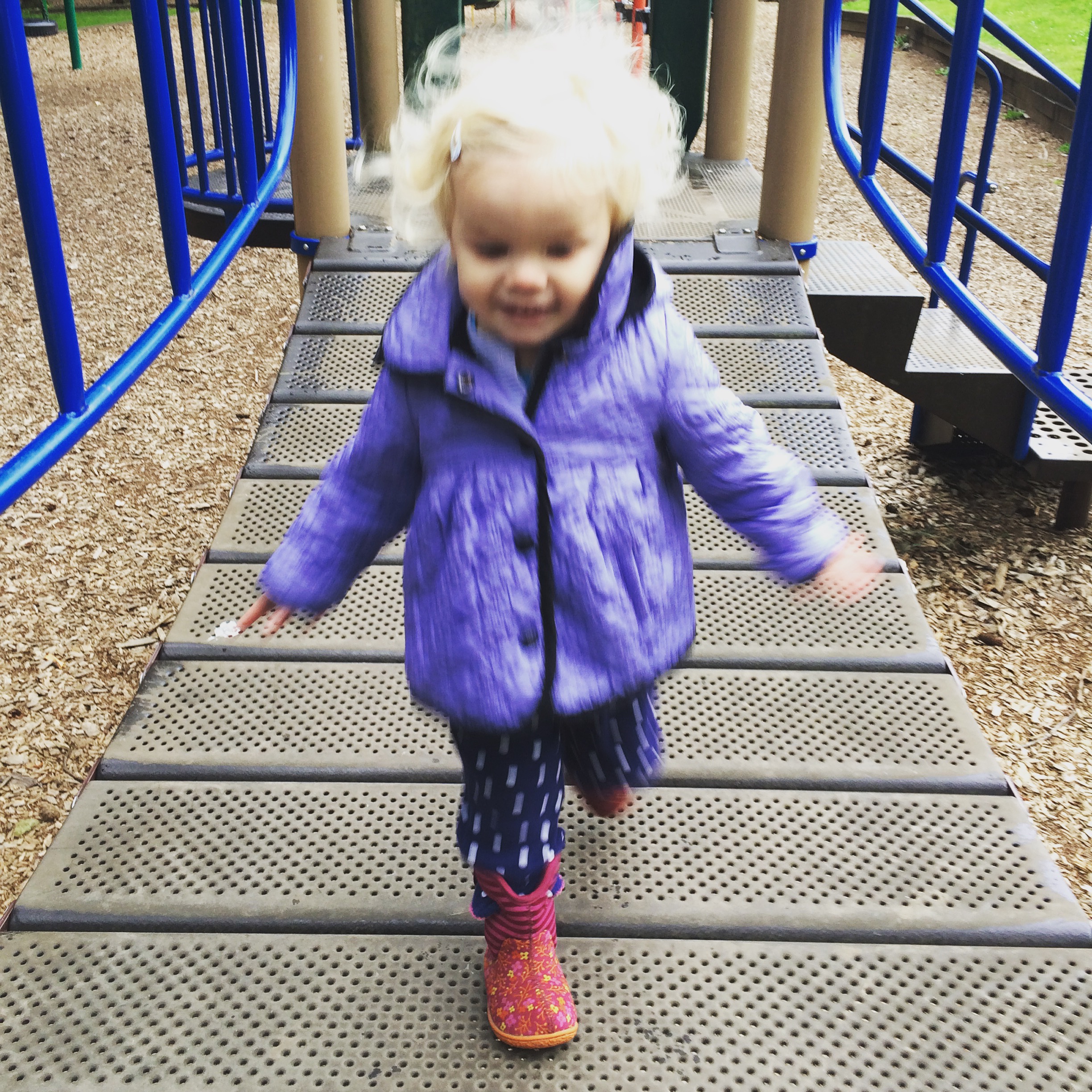 Toddler running on bridge playground